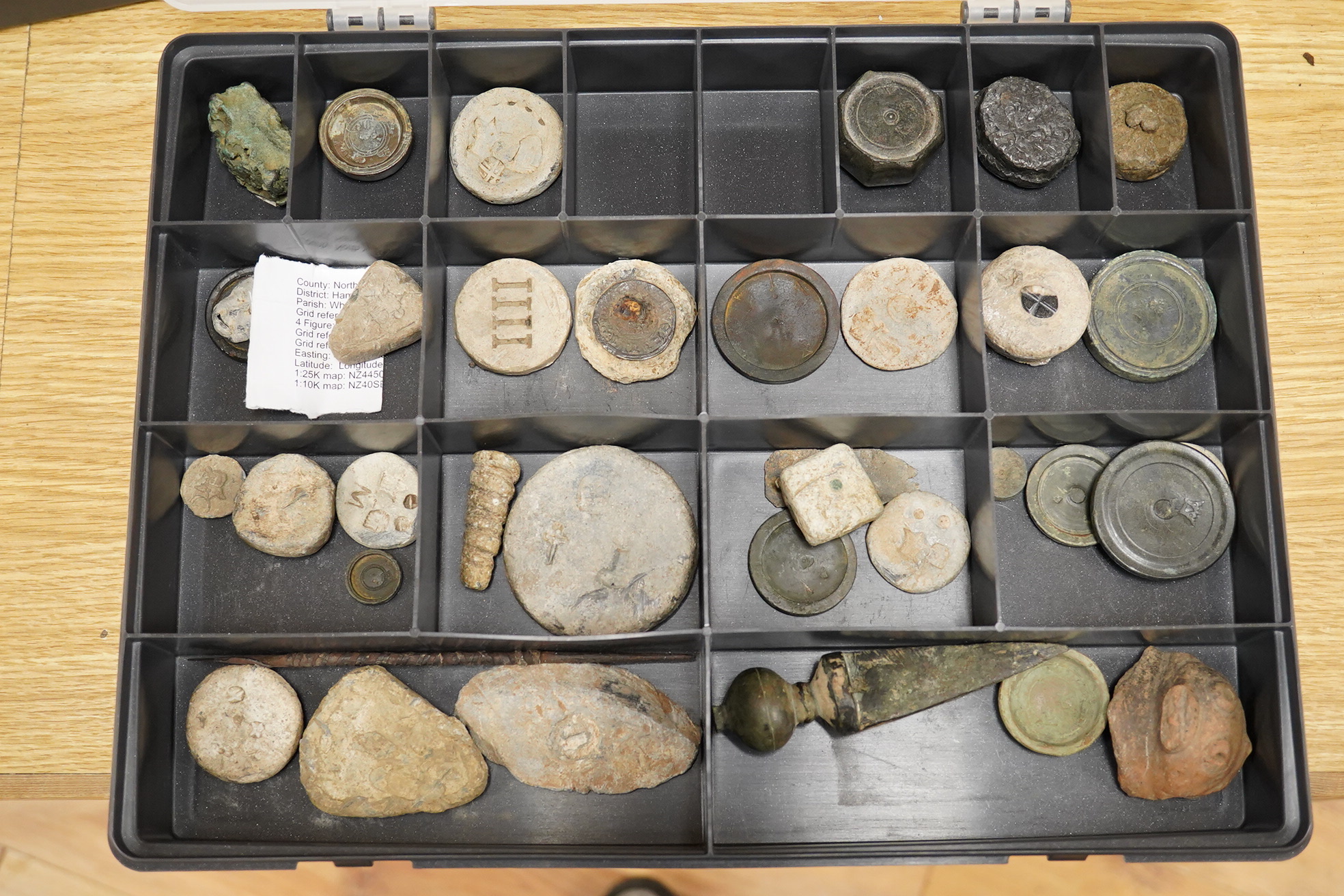 A collection of 16th century to 19th century bronze and lead circular trade weights, stamped with Royal Cyphers, weights, proof marks, the assay dagger for London, etc., contained within four plastic collector’s trays